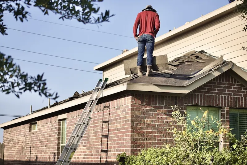Professional roofer working on a residential roof in Glasgow Village
